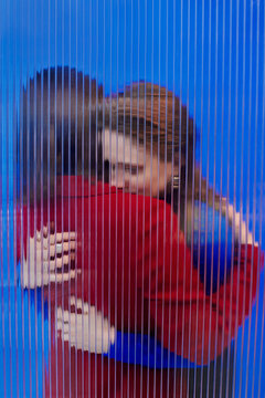 Two persons hugging each other against blue background