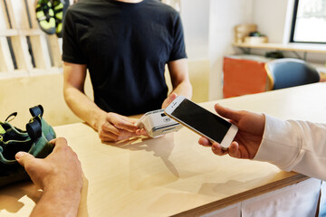 Anonymous female client paying for service in climbing gym