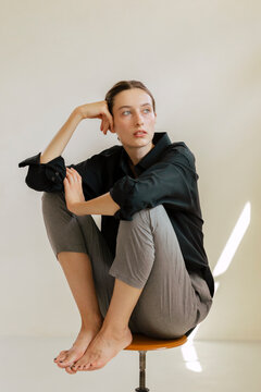 Portrait Of A Brunette Woman In Black Shirt and Gray Pants