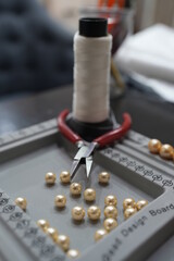 Close up of threading pearl beads onto wire to make artistic pearl necklace or bracelet. Jewelry maker