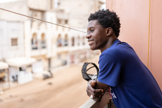portrait of man on the balcony of her house looking away