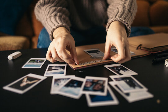 Woman making a scrapbook with polaroid photos
