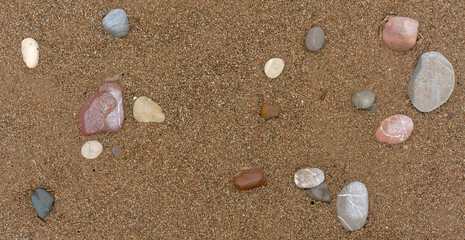 colorful pebbles on the sand close-up