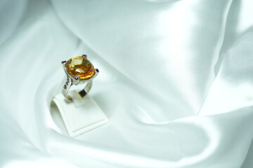 Yellow citrin Gems ring display show on white fabric satin. Luxury jewelry big head Gems