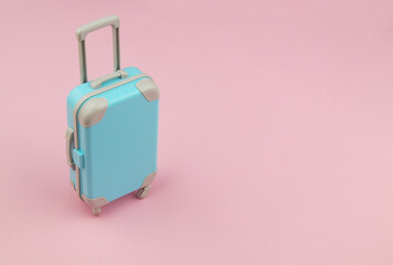 Travel suitcase on pink background with space for text. 