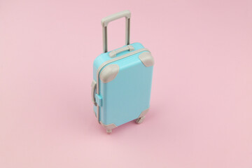 Suitcase on pink background with room for text. Travel and baggage concept.