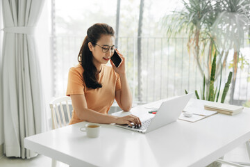 business woman at work talking on phone and taking notes