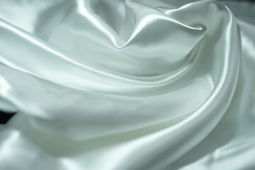 Obraz premium White satin fabric background with wavy soft folds for selling product. White Texture - light Wavy Glossy Silk Drapery. Shiny smooth fabric. Elegant background for design.