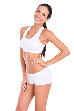 A fit young woman in sportswear posing with her hand on her hip isolated on a PNG background.