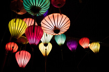 Low angle view of illuminated colorful lanterns in darkroom