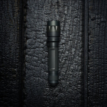 Flashlight on Burned Wood Background