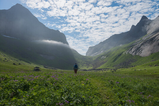 Female hiker hiking towards mountain pass on return from Horseid beach