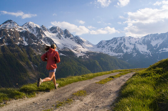 A woman running on a dirt road in Courmayer Italy