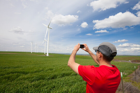 Man photographing wind turbines at Lower Snake River Wind Facility, Lower Snake River, Washington, USA