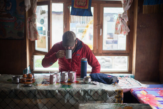 Man drinking tea in village town in Himalayan Mountains