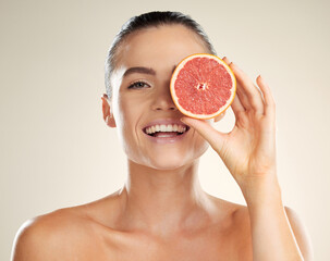 Beauty, skincare and grapefruit for portrait of a woman with natural skin dermatology product. Vitamin c fruit on face aesthetic model in studio for sustainable cosmetics for health and wellness