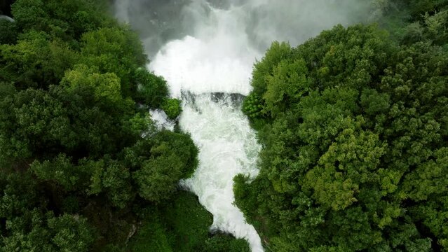 Water Flowing To Marmore Falls With Lush Green Forest In Umbria, Italy. - aerial overhead