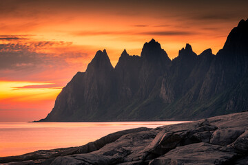 Stunning midnight sun over the Tungeneset (Devil's Teeth) in Senja Island,  Norway