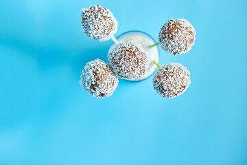 Delicious homemade popcake coconut and dark chocolate cake pops on a blue background, festival desserts, tasty food