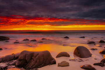 Fototapeta na wymiar Dramatic midnight sunset with amazing colors over Uttakleiv beach on Lofoten Islands, Norway