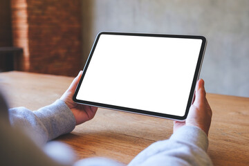 Mockup image of a woman holding digital tablet with blank white desktop screen