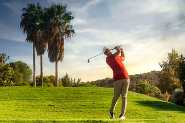 golf shot man. professional golf swing. Golf player teeing off. Front view of golfer finishing swing with a smile. Full length of golfer playing on the course. Golfer hitting golf shot with club - Powered by Adobe