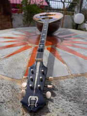 The national Greek stringed plucked musical instrument Bouzouki lies on a marble table in Greece