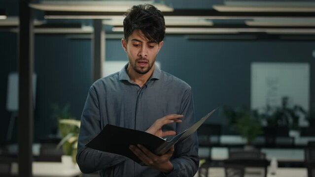 Frustrated annoyed indian arabian man male adult businessman auditor office accountant work in company read papers business documents bank loan documentation financial mistake debt problem bankruptcy