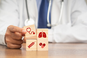 A doctor hand holding wooden cubes with icons of health