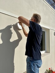 Man fixing an exterior wall light