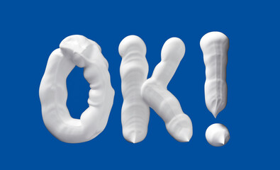 OK word made of shaving foam letters on blue background