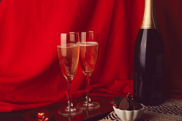 Traditional romantic Valentines day background with bottle of champagne, glasses, chocolate candies aesthetics