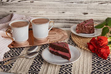 Pastel coffee time with chocolate cherry cake pieces, coffee cups among red roses. St Valentines Day holiday aesthetics.