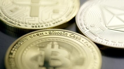 Golden cryptocurrency coins on dark surface; close-up shallow focus reveal