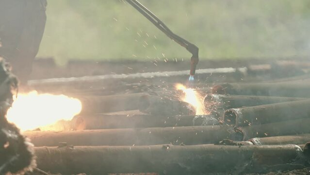 Torcher cutting metal in slow motion at a scrapyard, big power tools 120fps