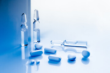multivitamin pills and vaccine ampoules close-up