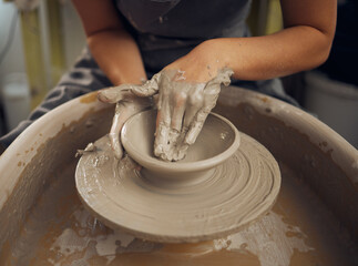 Clay, pottery or hands in designer workshop working on an artistic cup or mug mold in small business studio. Hand of creative artist or worker manufacturing handicraft products in sculpture process