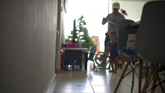 Slow motion of bubbles pumping against the wall with a little latin boy and his father in the background inside their home