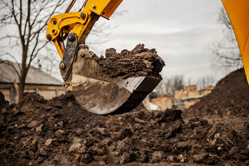 Close up of a earthmover digging soil on construction site.