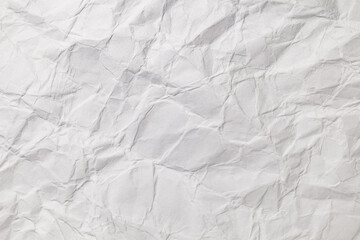 Crumpled white paper with bends and fractures, background texture, close-up macro top view