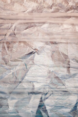 cellophane on metallic crumpled blue background. plastic textures. background for card or...