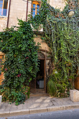 Fototapeta na wymiar Decorated with a green climbing plant entrance to the building in the old city of Yafo, in Tel Aviv - Yafo city, Israel