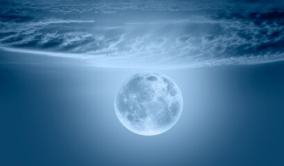 Night sky with full bright moon in the clouds "Elements of this image furnished by NASA"