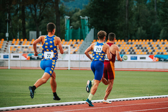 High-energy image of male athletes in middle distance race. Perfect for sports and fitness brands, promoting strength and determination