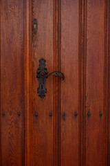 Old handle on a wooden door. beautifully shaped doorknob.