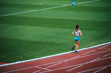 Alone female athlete on the track while race
