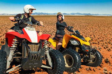 Quad driving people - happy smiling couple bikers in sand desert. Namib, Namibia.