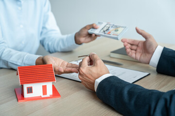 Real estate broker agent holding filing keys to the customer after signing rental lease contract of...
