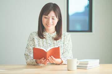 読書をしながらティータイムを楽しむ女性