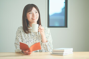 読書をしながらティータイムを楽しむ女性